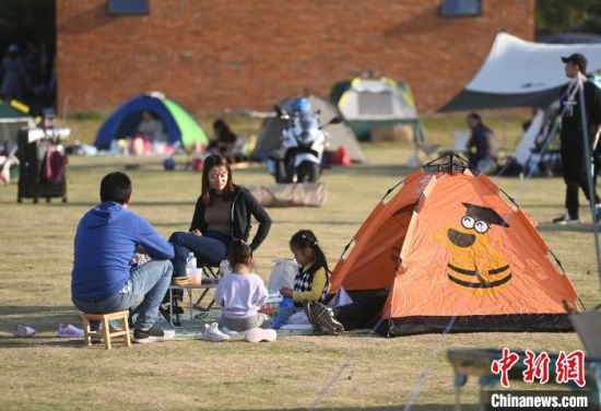 市民在帐篷旁休闲，享受秋日暖阳。　韩苏原 摄 